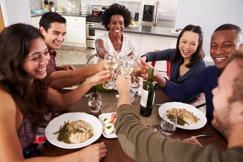 men and women celebrating having drinks and food. 